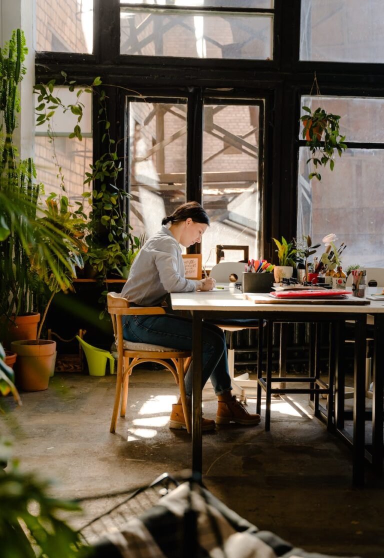 photo of woman sitting by the table while writing