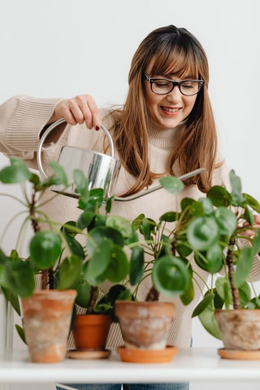 smiling woman watering plants