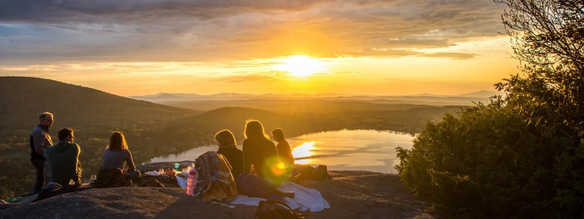 group of people sirring under sunset