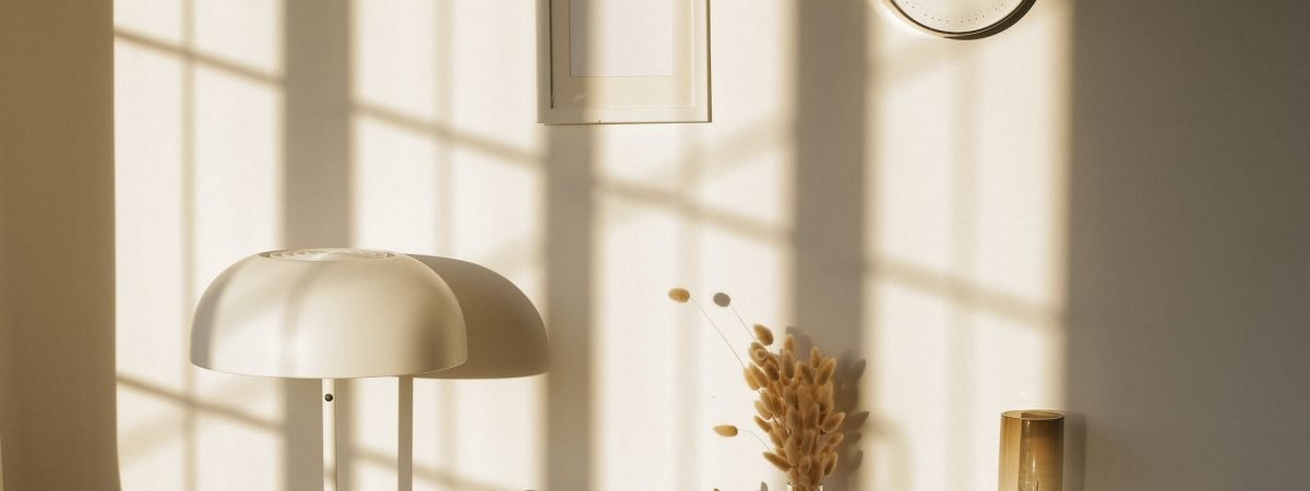 room interior with lamp and vases on table near wall