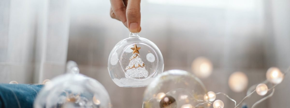 person preparing glass ball for christmas decoration