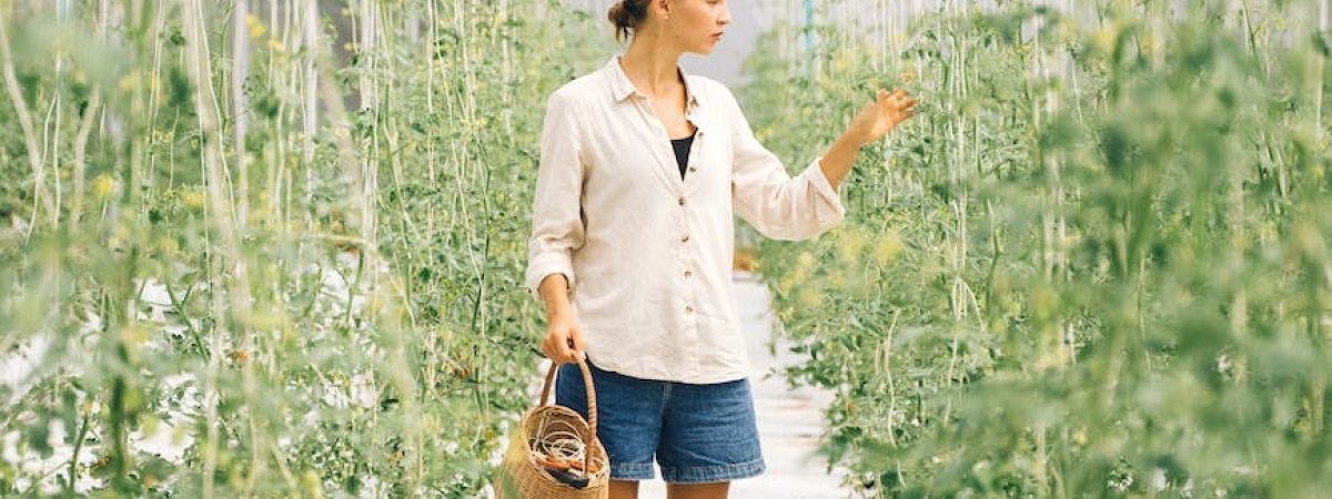 a woman looking at the plants in the greenhouse