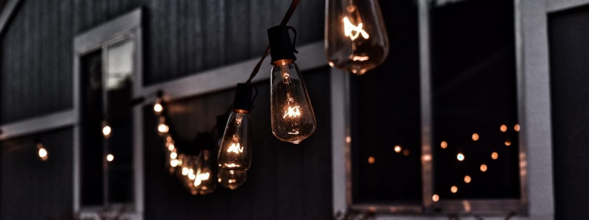 piled hanging lighted bulb beside house