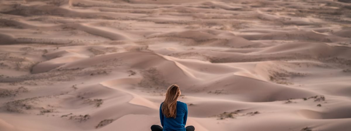 woman sitting on sand field